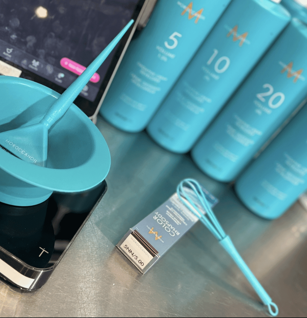 Hair coloring tools and Moroccanoil products neatly arranged on a salon counter.